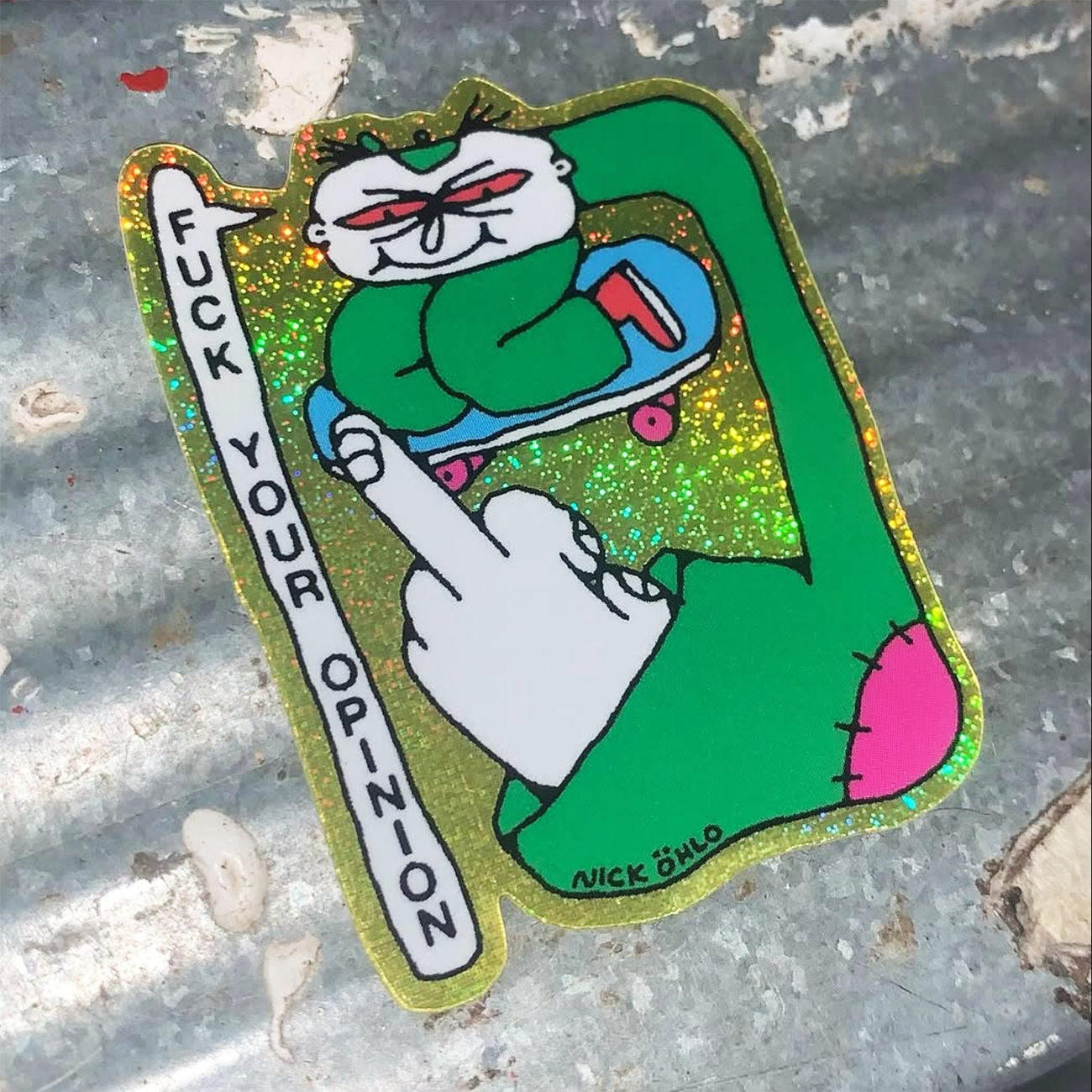 Pixie Dust sticker on a metal background, showing a cartoon character on a skateboard holding up his middle finger with the text "Fuck your opinions".