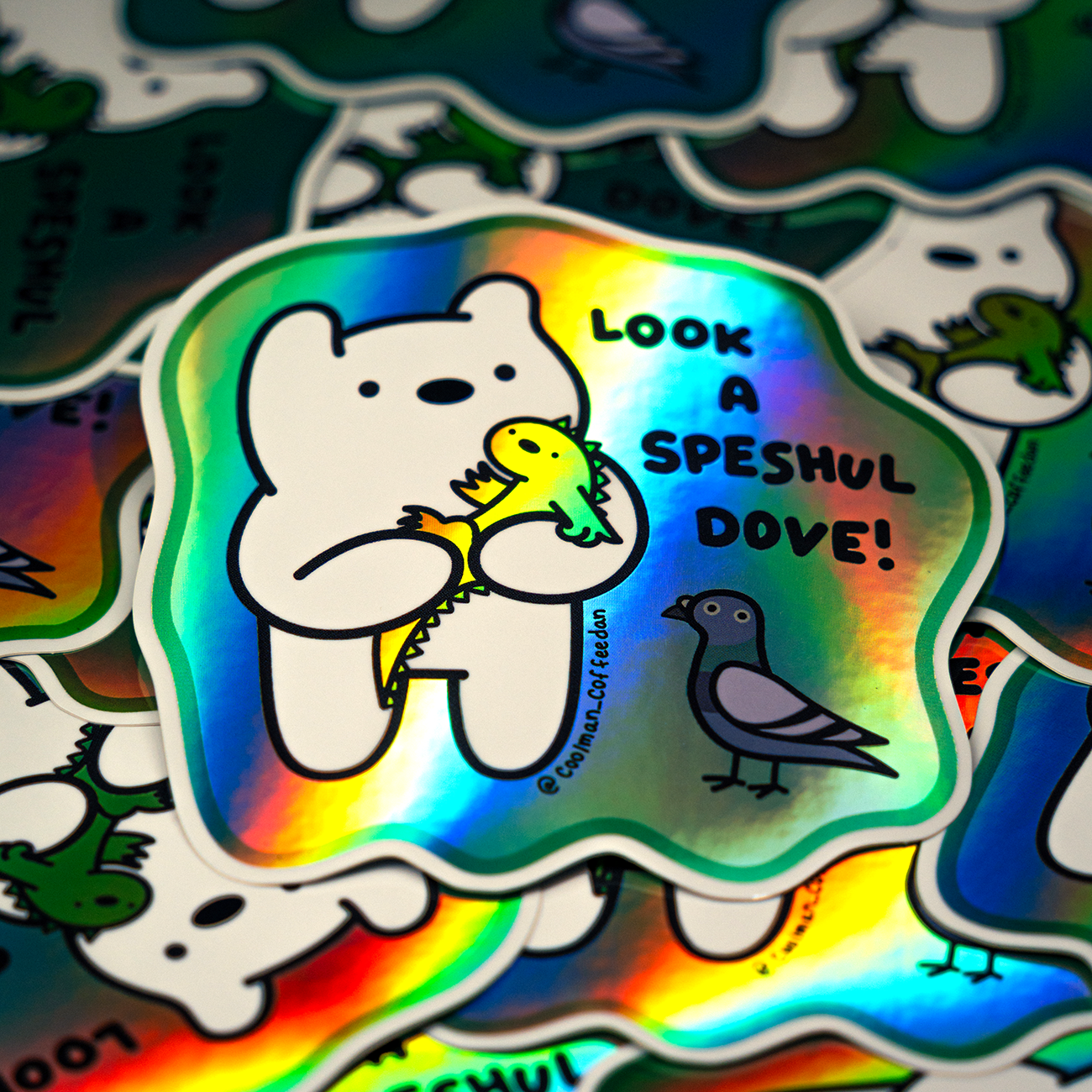 Holographic sticker of a cartoon bear holding a yellow dinosaur with a pigeon beside them, text reads "Look a Speshul Dove!"