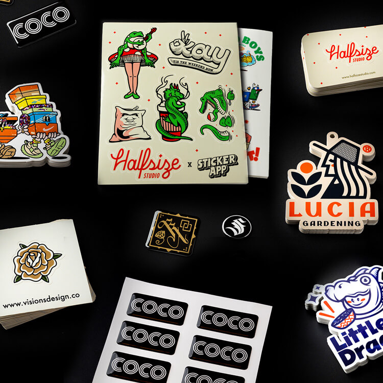 Various sticker products on a black surface, including sticker sheets, epoxy stickers, and die-cut stickers.